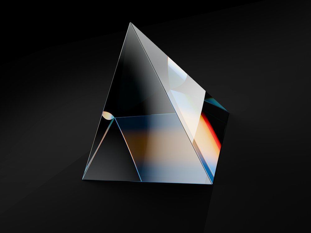A faceted reflective prism with subtle spectral highlights on a dark background.